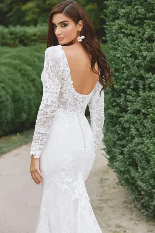 model is wearing a long sleeve lace fit and flare wedding dress