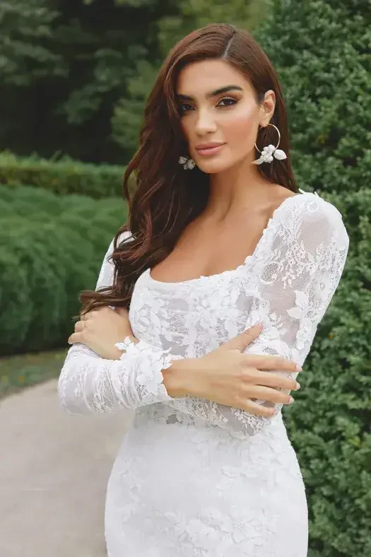 model is wearing a long sleeve lace fit and flare wedding dress