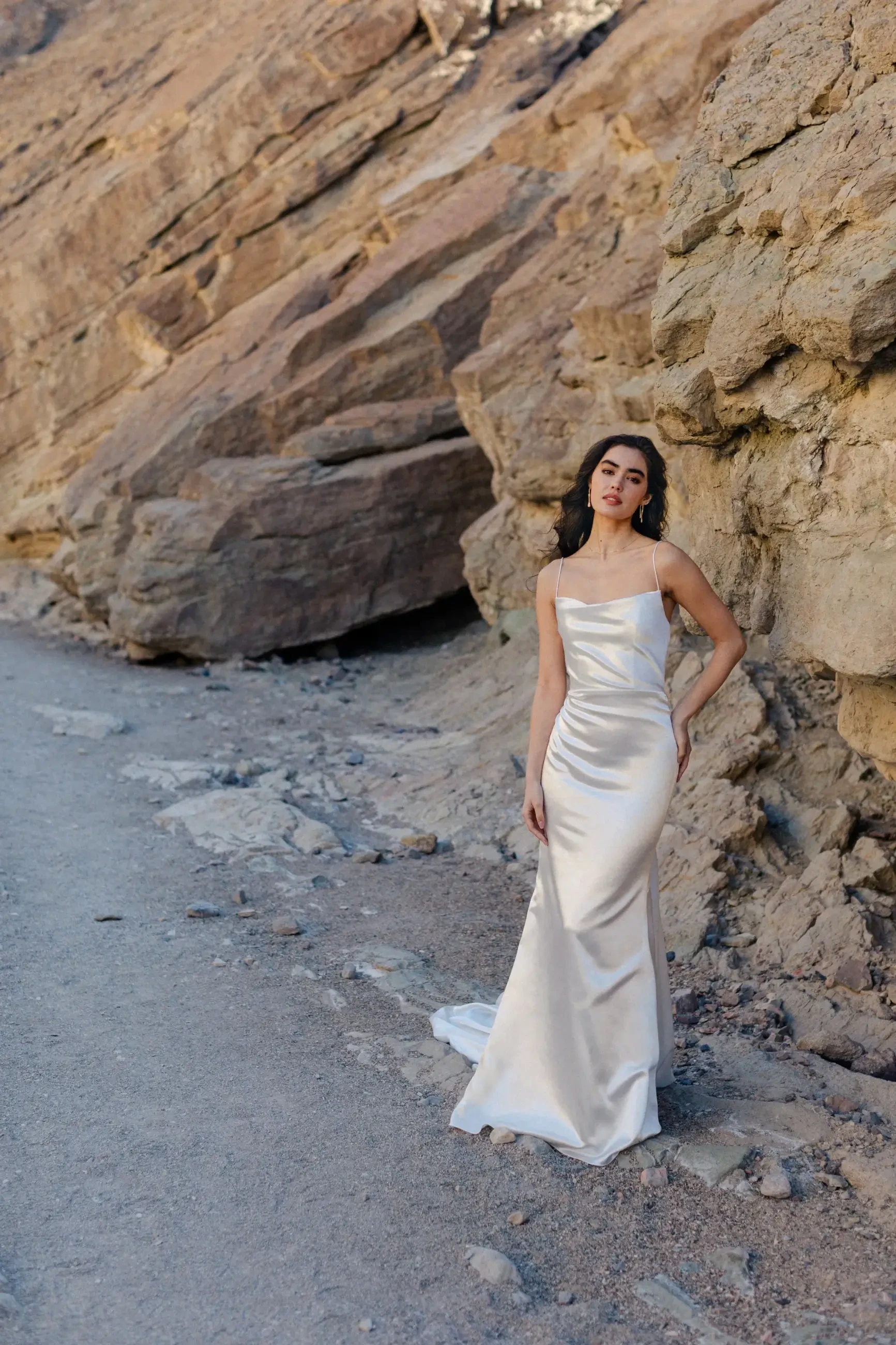 model is wearing a sleek satin sheath wedding dress