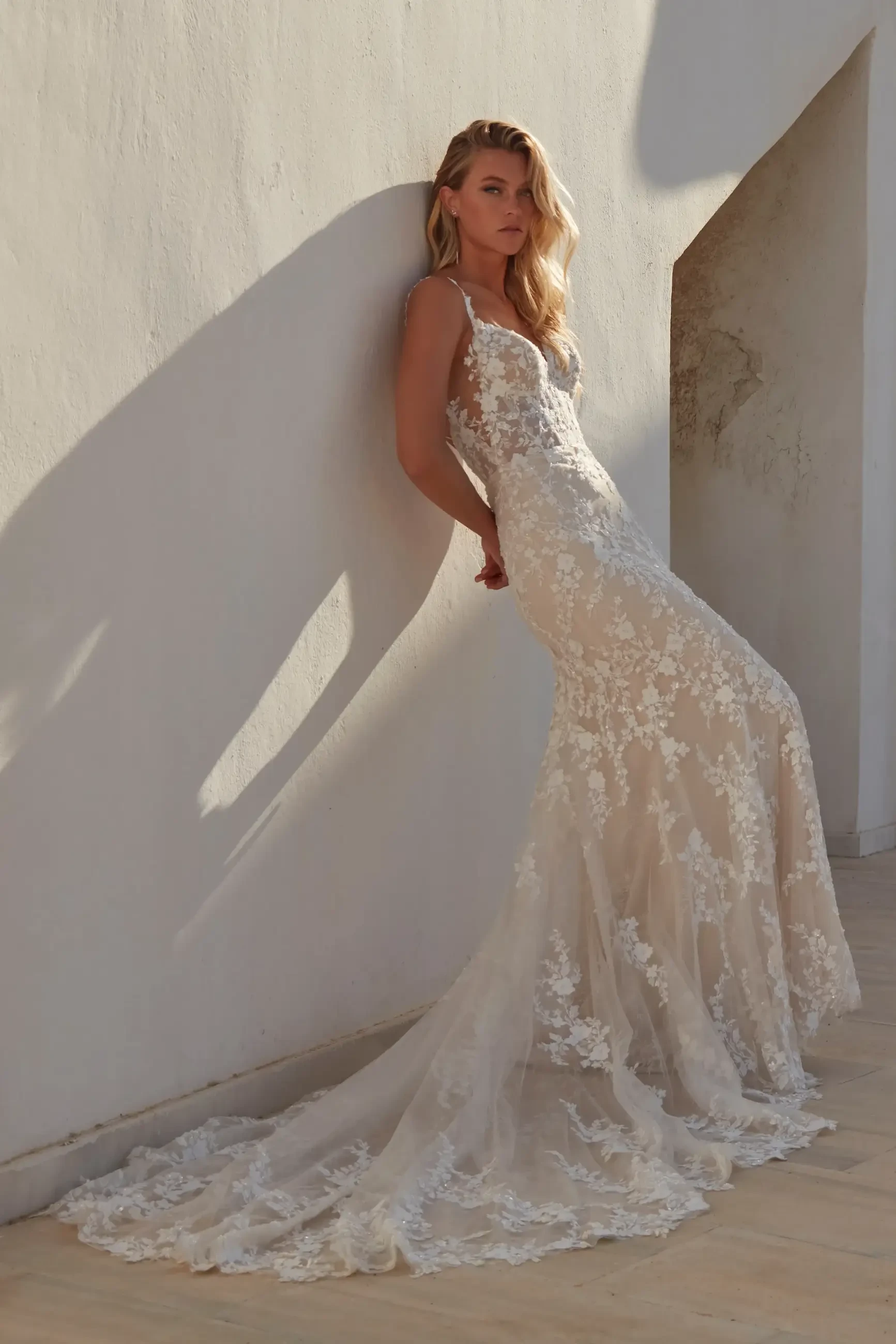 model is wearing a sleeveless lace fit and flare bridal gown with a blush underlay