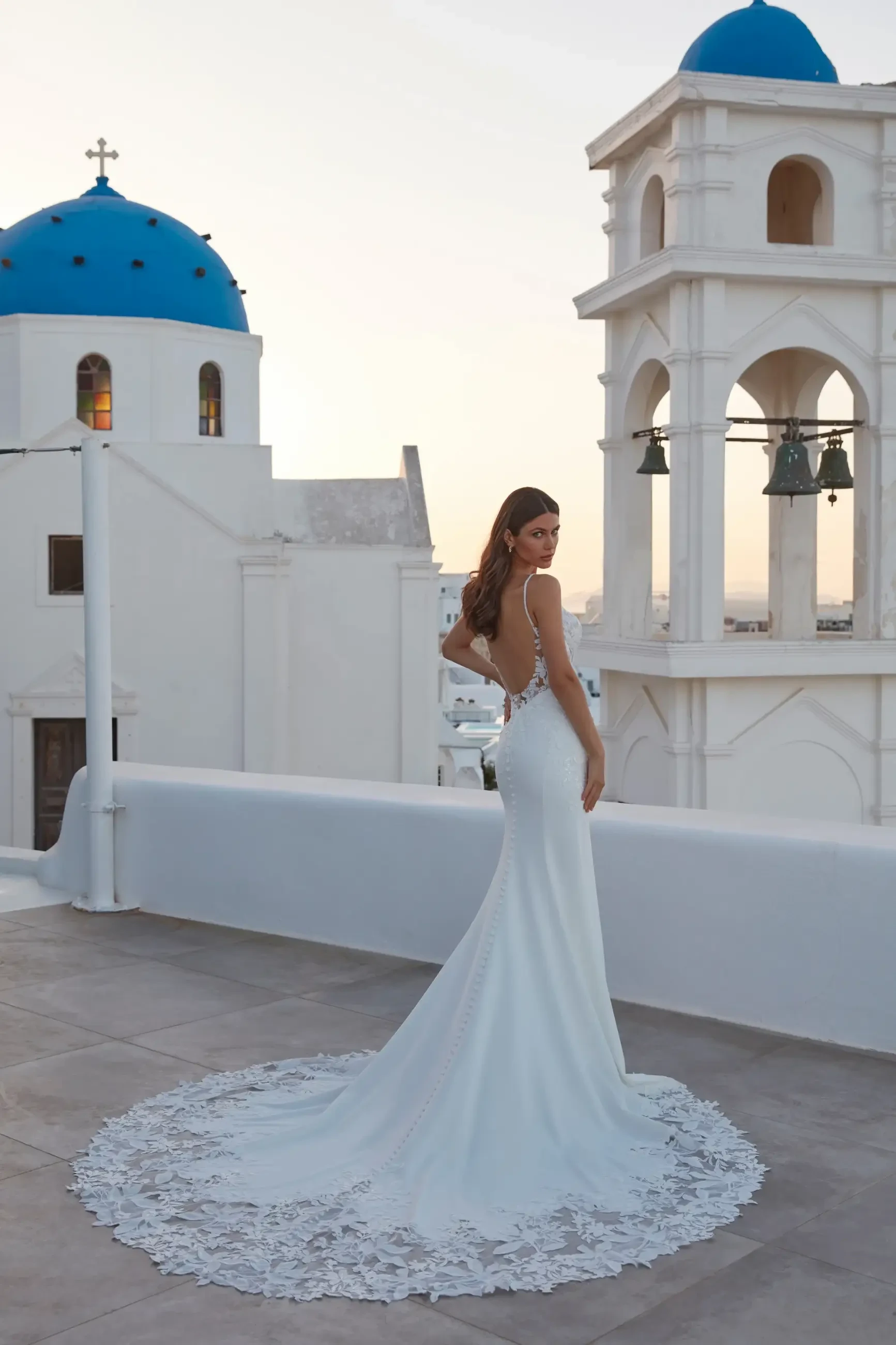 model is wearing a sleeveless fit and flare bridal gown with a low scoop back