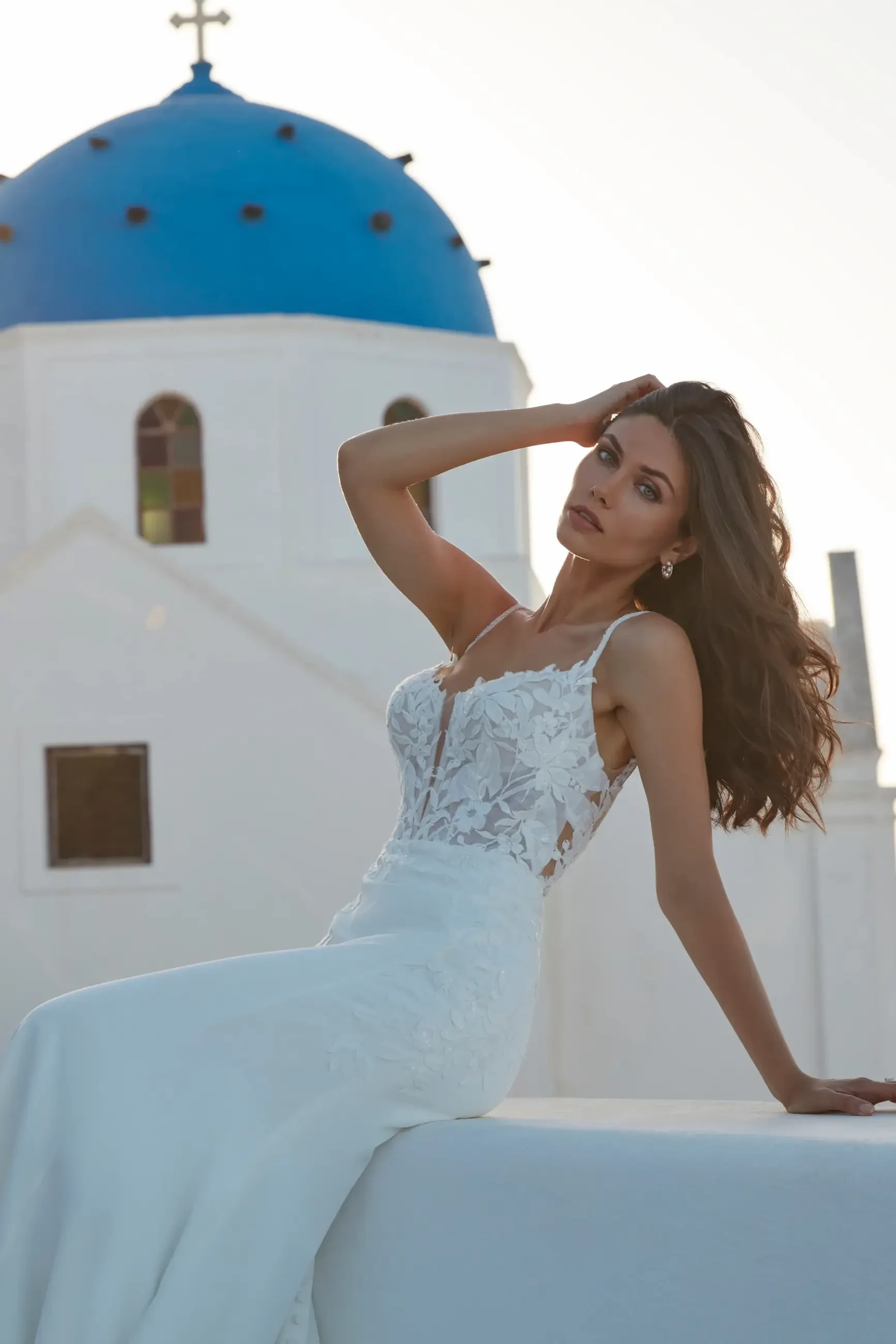 model is wearing a sleeveless fit and flare bridal gown with a low scoop back
