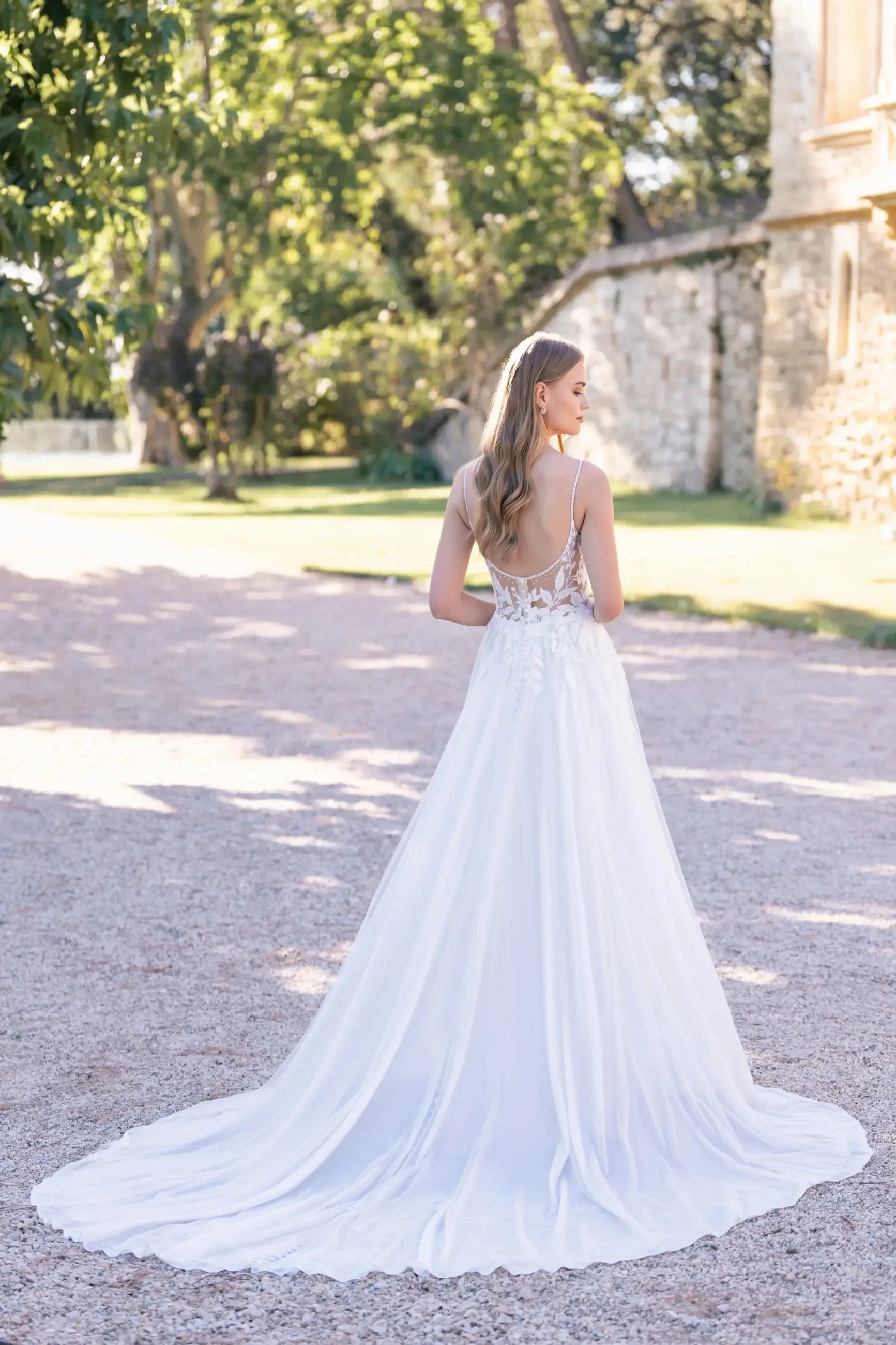 Model is wearing an a-line wedding dress with dimensional beaded lace appliques