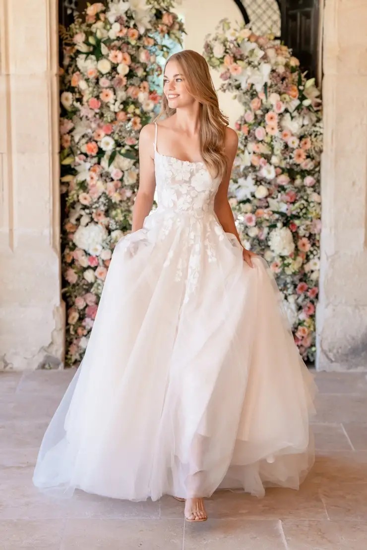 Model is wearing an a-line tulle and lace wedding dress by allure romance