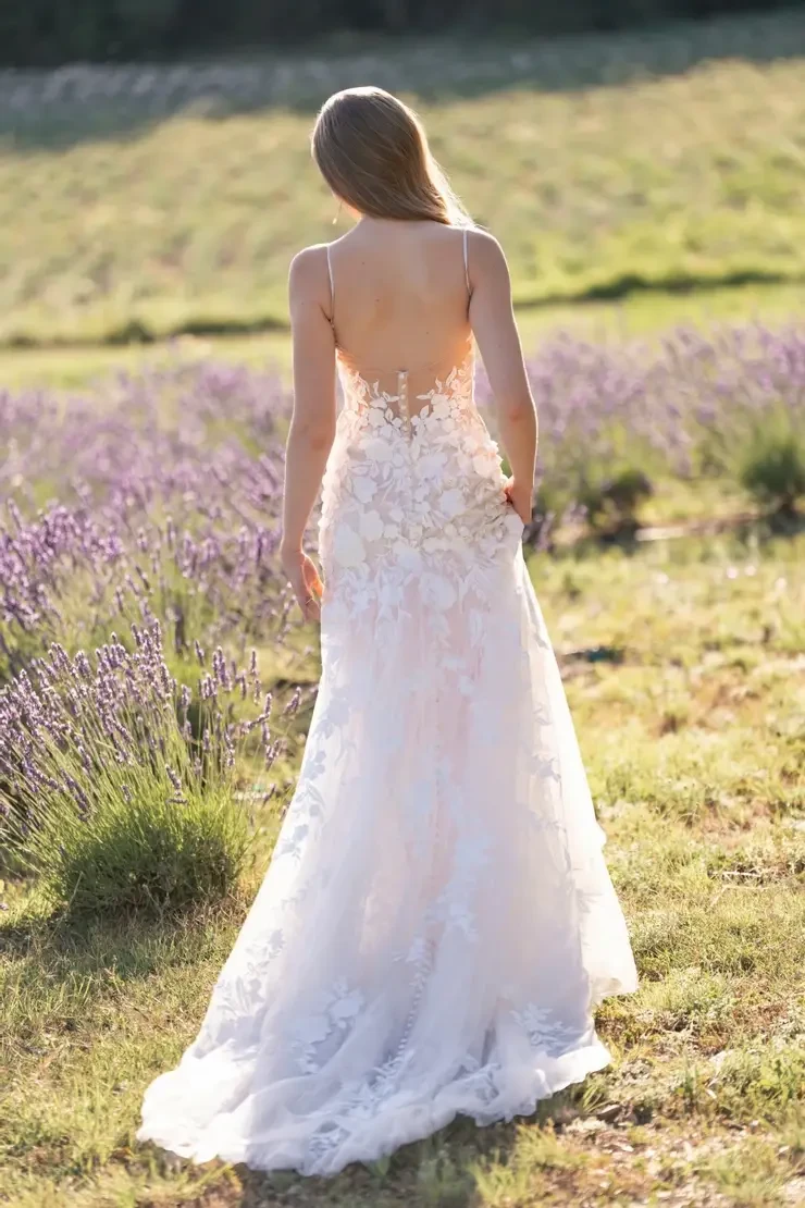 Model is wearing a sheath wedding gown with lace appliques by allure romance