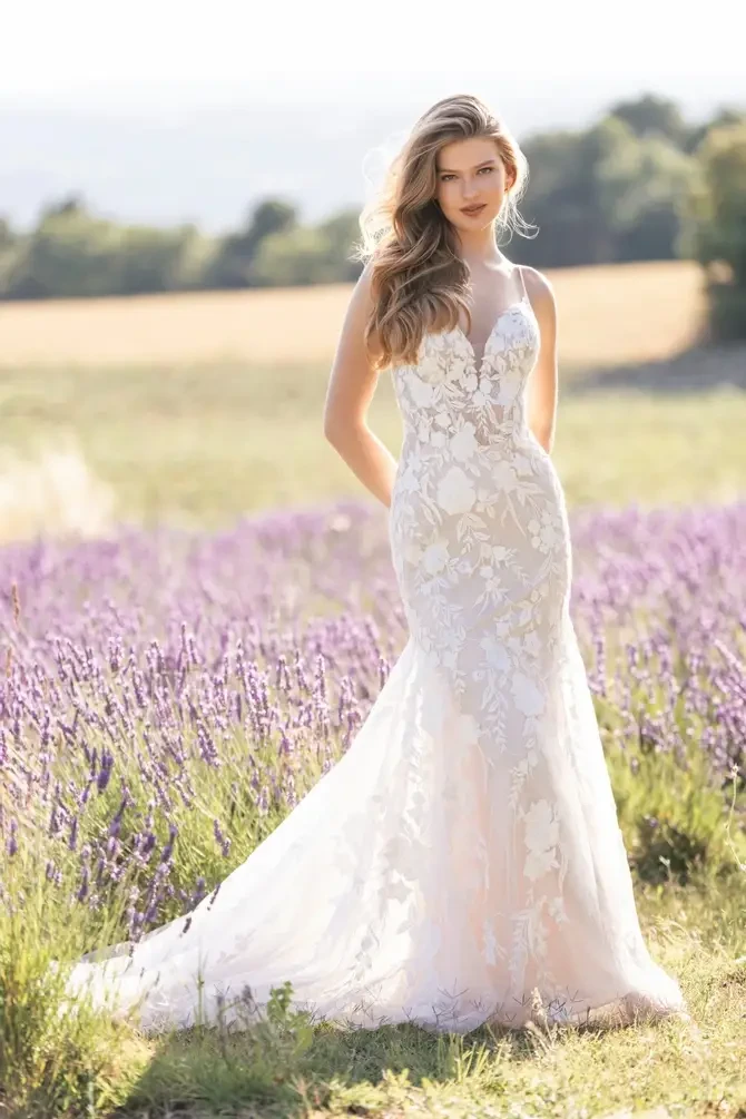 Model is wearing a sheath wedding gown with lace appliques by allure romance