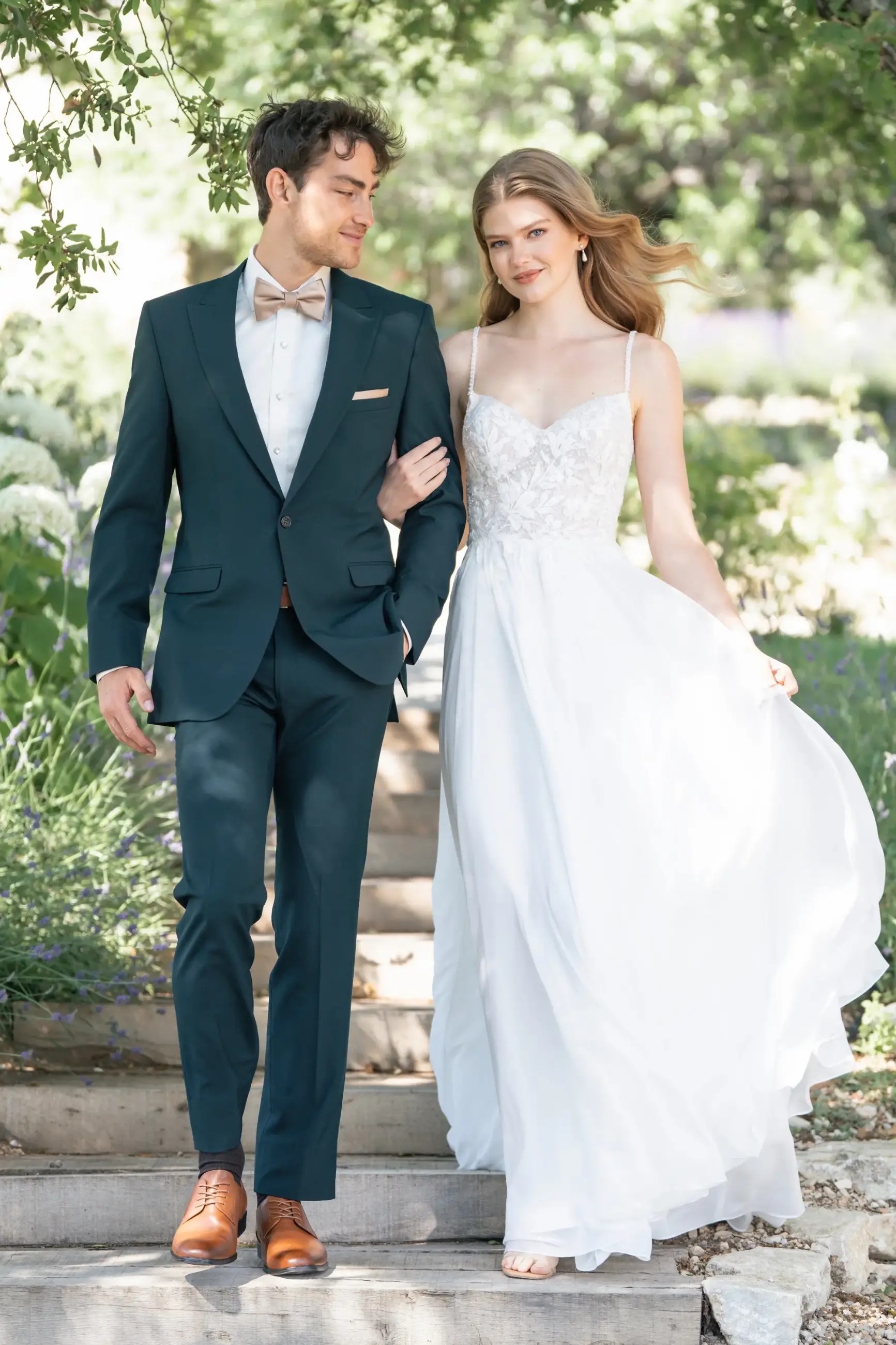 Model is wearing an a-line chiffon wedding dress with beaded sequin lace appliques